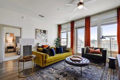 a living room with a yellow couch and a large window